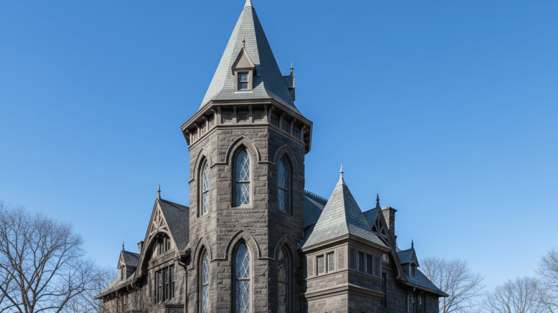 _A large gothic stone building featuring a tall steeple, adorned with intricate towers and turrets.