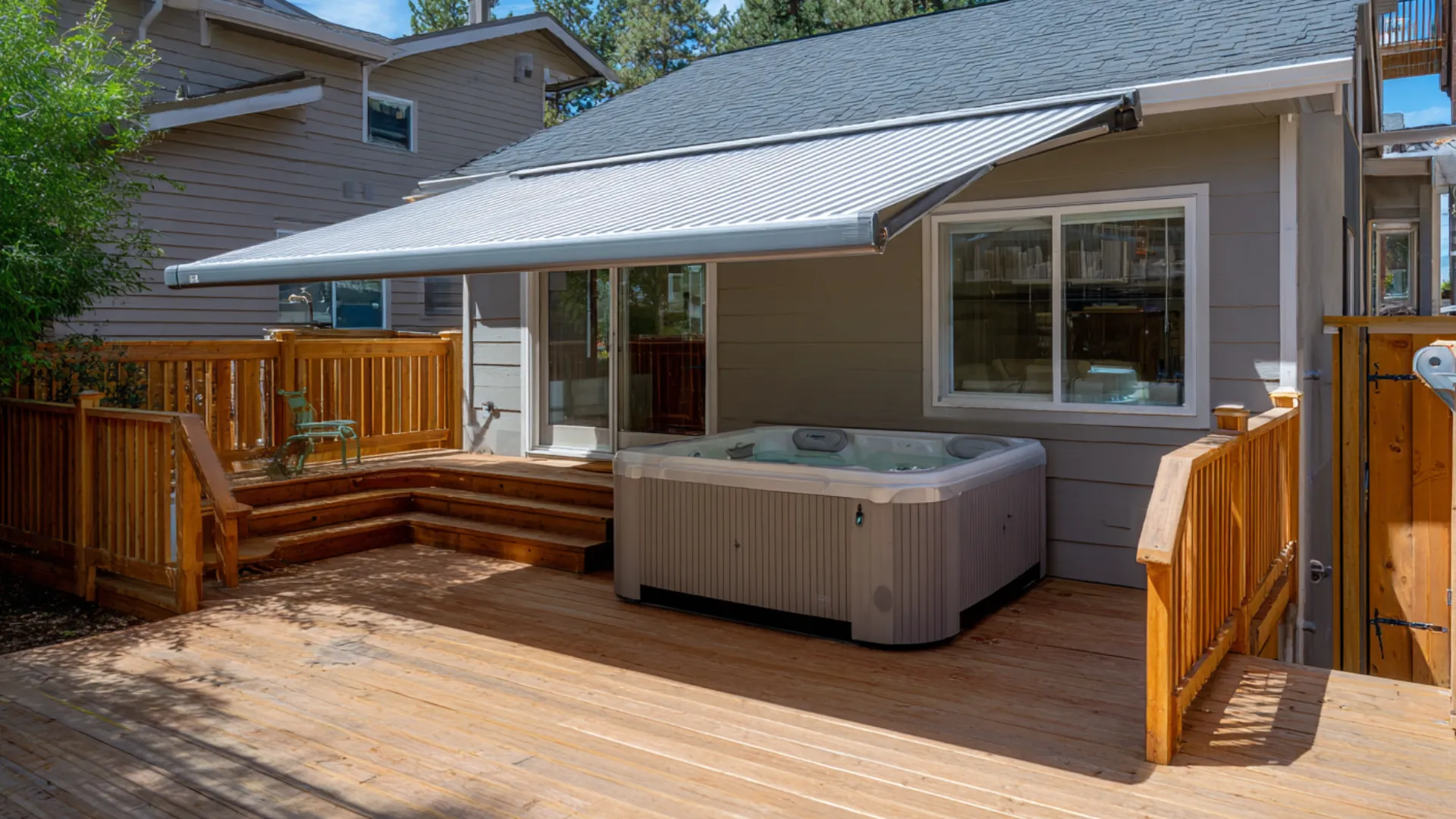 Attached deck with hot tub under a retractable awning beside the back door scene