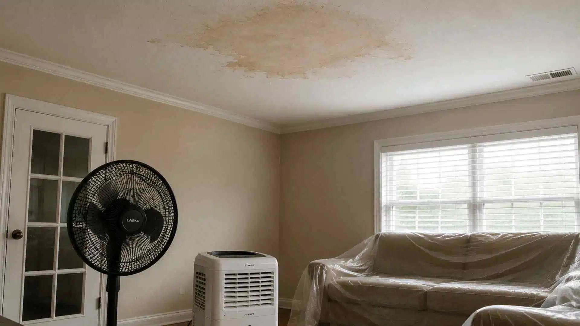 Drying water-damaged ceiling with dehumidifier and fan under AC pipe leak in lived-in home interior