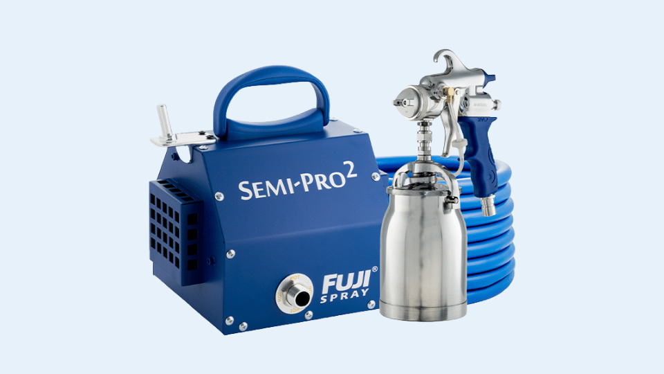 Fuji Semi-Pro 2 HVLP spray system with blue compressor unit, spray gun, and coiled hose on a light background.