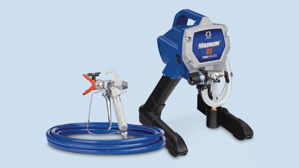Graco Magnum X5 TrueAirless electric airless paint sprayer with spray gun and coiled hose on a light background
