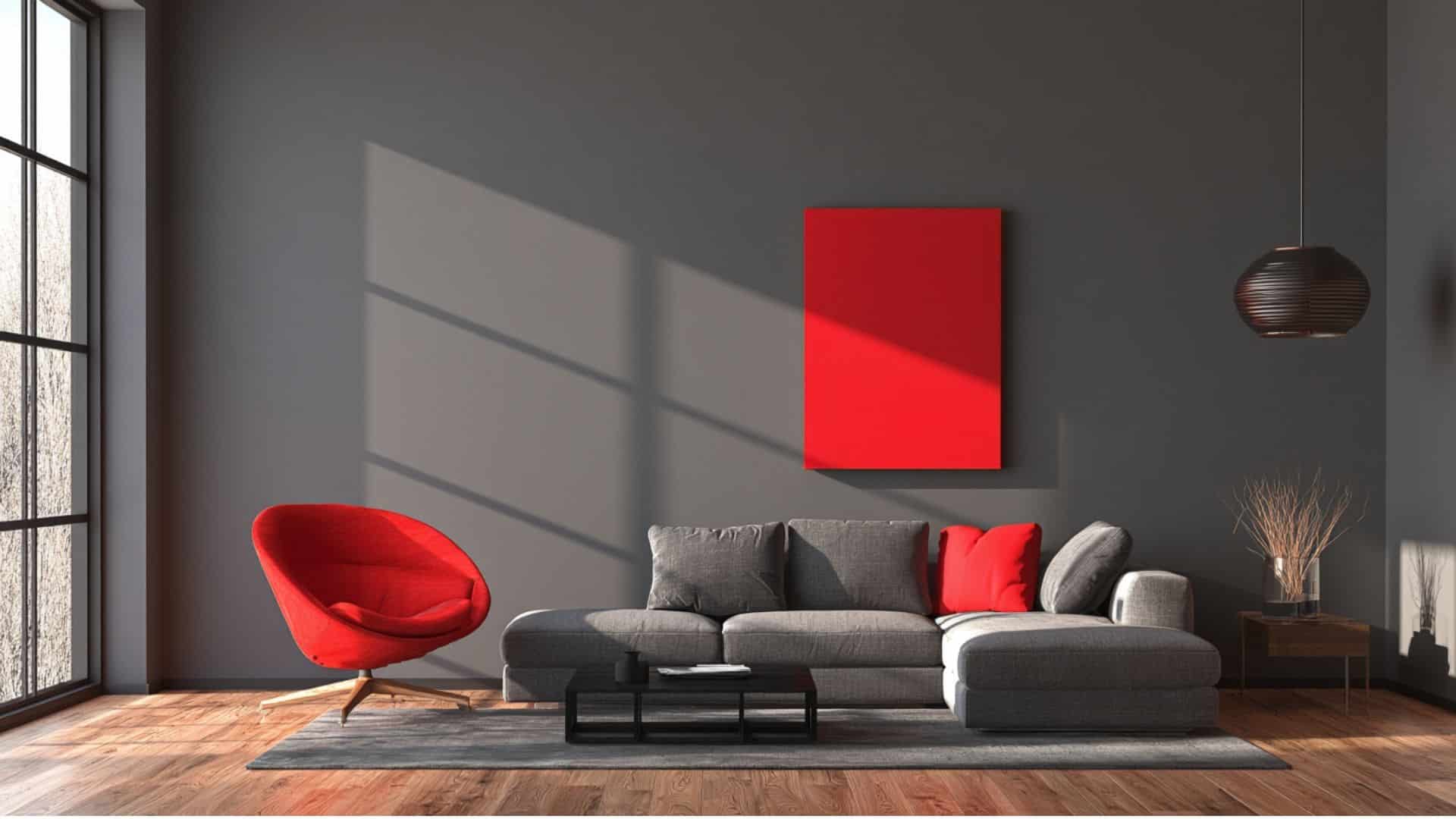 Gray living room with red accent chair and artwork, strong contrast in a modern minimalist space.