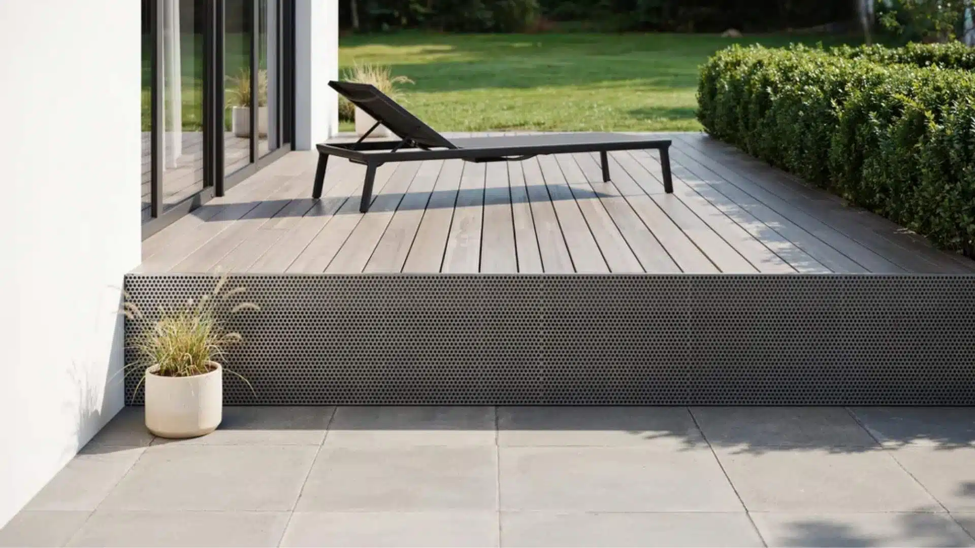 Dark perforated metal deck skirting panel beneath a wood deck with patio below.