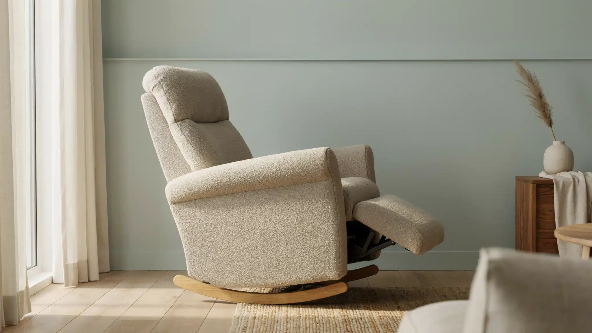 Rocker recliner chair in living room with gentle curved base and extended footrest in calm interior.