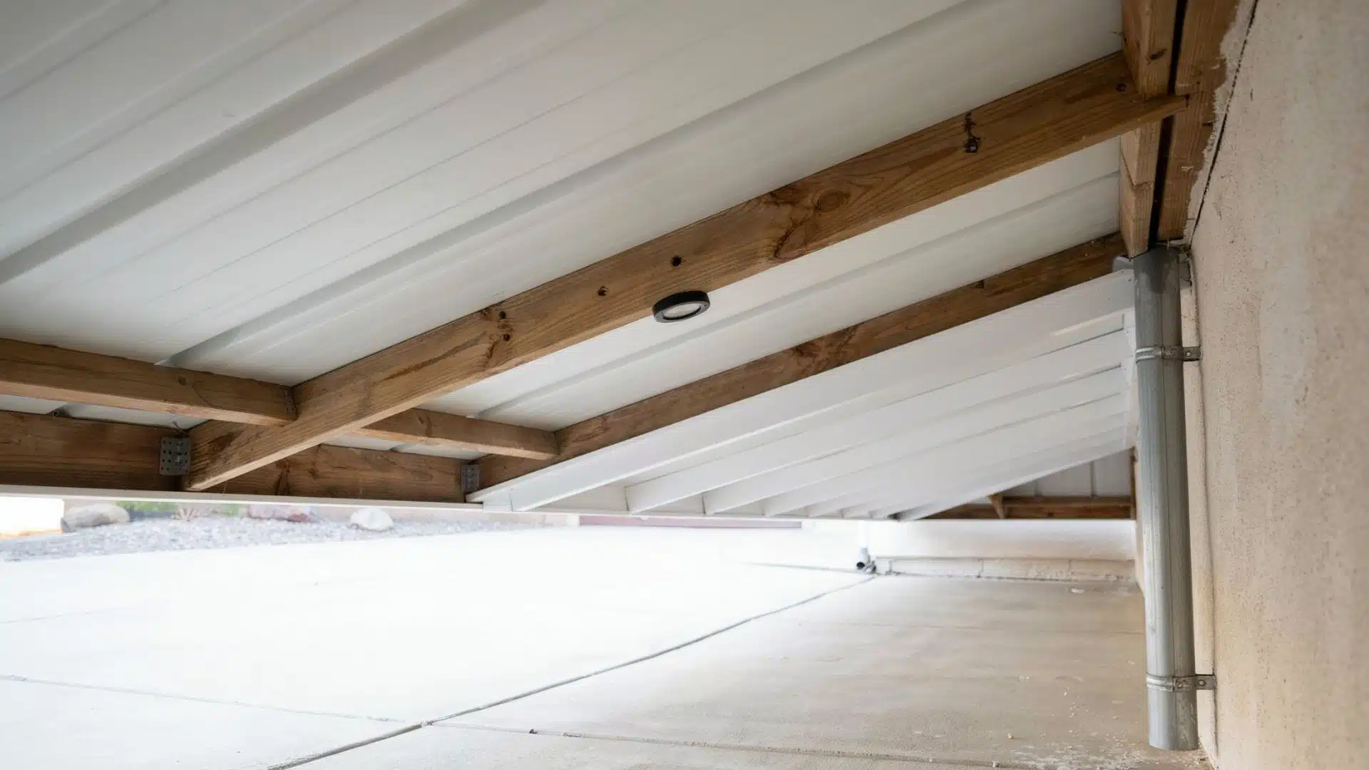 White waterproof ceiling panels installed beneath a raised wood deck framing structure.